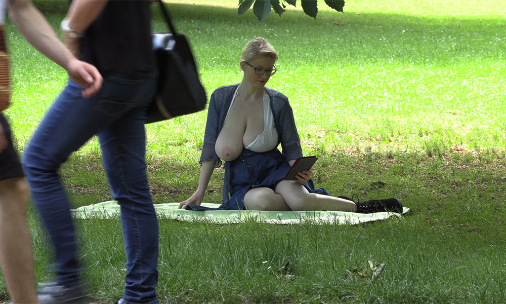 Blonde in the park with one large breast hanging out for all to see