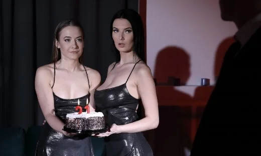 Two babes in black dresses holding birthday cake